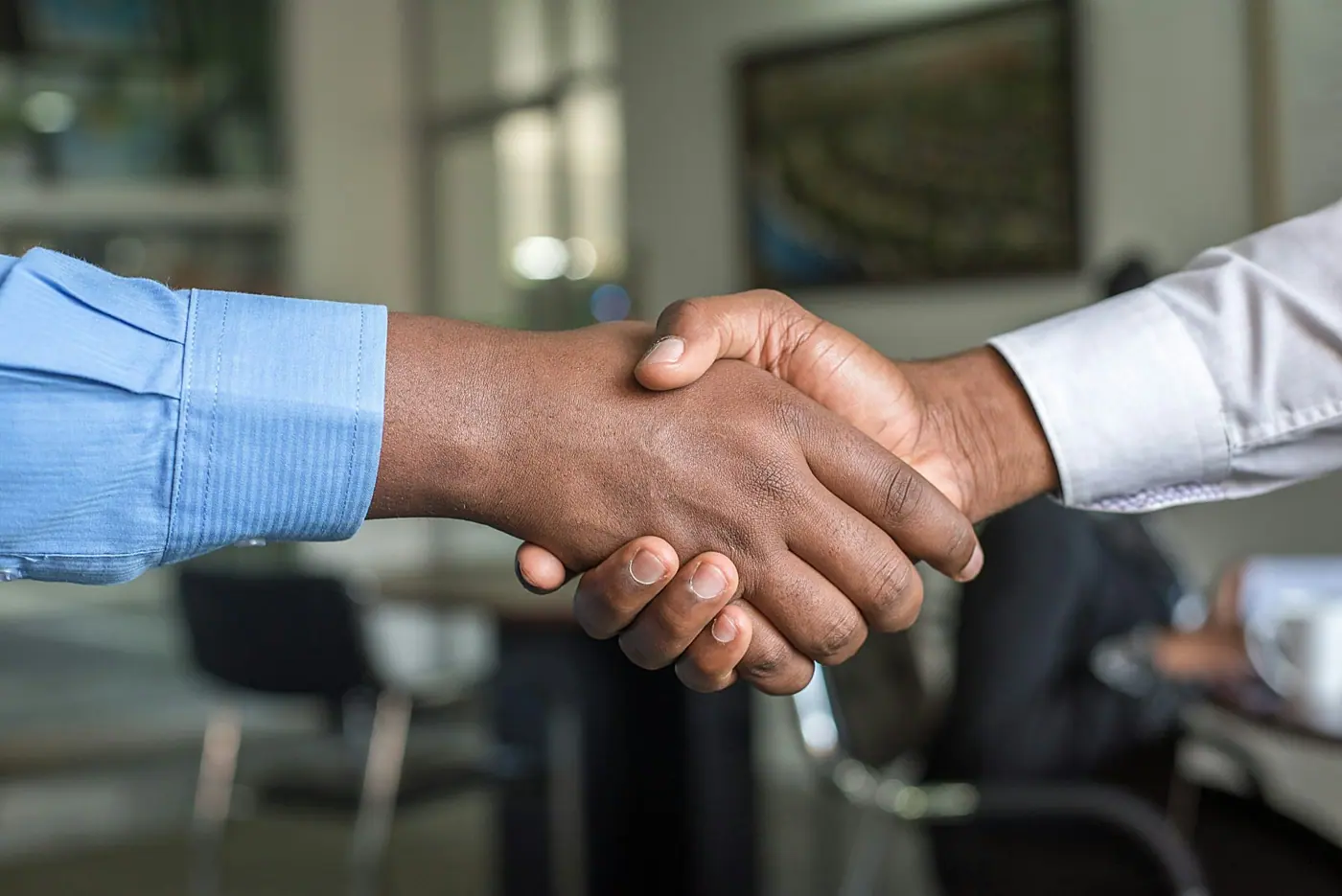 Two people shaking hands across a desk at the close of a letting